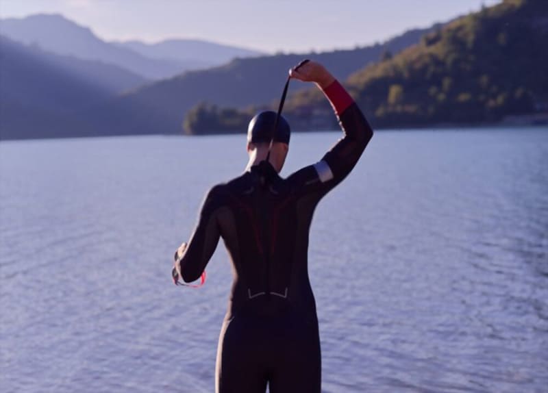 triathlon athlete getting ready and prepare wetsuit for swimming training