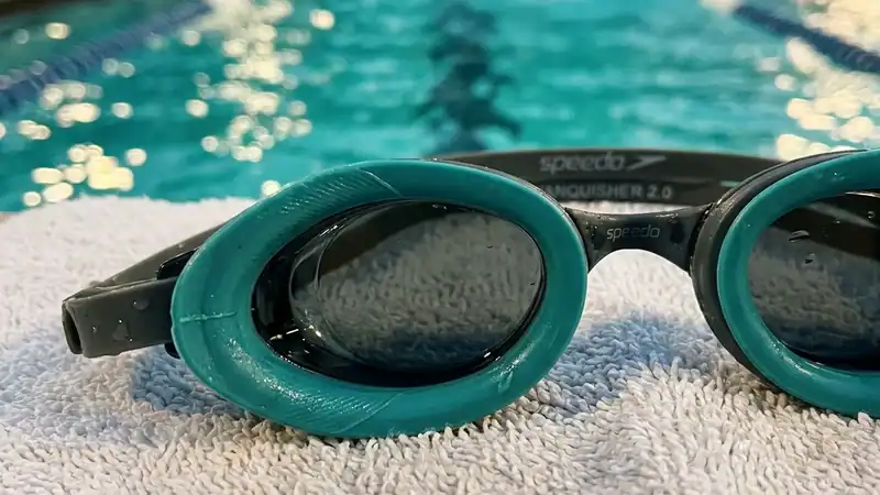 Close-up of swim goggle silicone gasket against pool towel, periorbital seal detail.