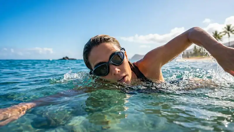 Swimmer wearing polarized goggles in clear open water