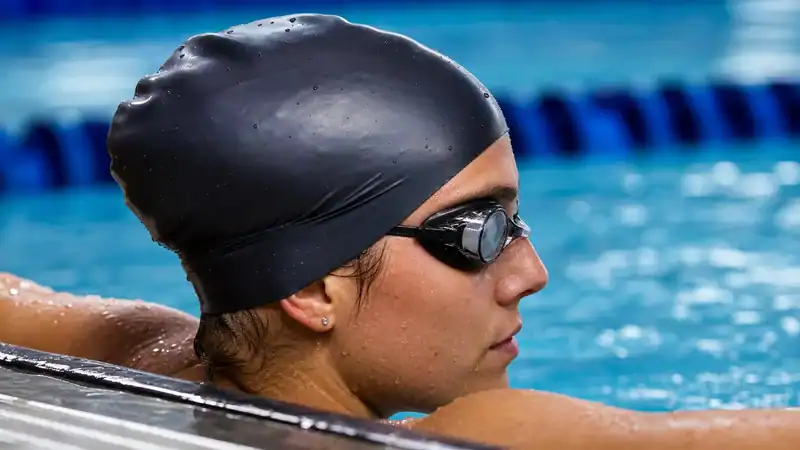 Close-up of goggle straps tucked beneath a racing swim cap